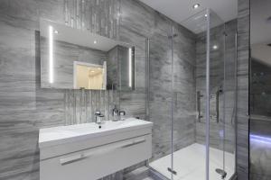 La salle de bains est pourvue d'un lavabo, d'une douche et d'un miroir. dans l'établissement Luxurious 2 King-size bed flat with Patio, à Londres