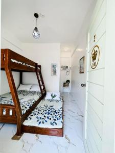 sypialnia z łóżkiem piętrowym i białą ścianą w obiekcie The Kroun Seafront Residences 