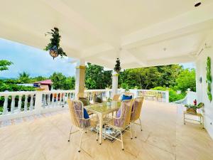 an outdoor patio with a table and chairs at The Kroun Seafront Residences in Agdañgan