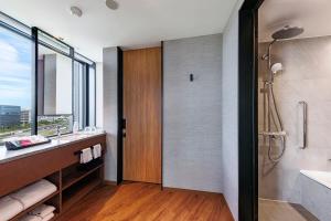 a bathroom with a shower and a sink and a mirror at Hotel Metropolitan Tokyo Haneda - 2023-10-17 Grand Opening in Tokyo