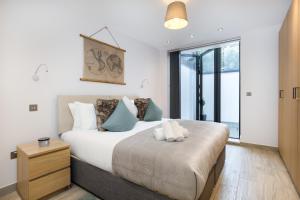 - une chambre avec un lit king-size et une fenêtre dans l'établissement Luxurious 2 King-size bed flat with Patio, à Londres