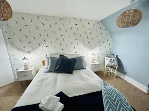 1 dormitorio con 1 cama grande con pájaros en la pared en Honeysuckle cottage, a cosy coastal retreat, en Dornoch
