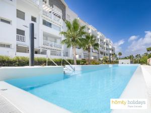 una piscina frente a un edificio en Homity Exclusive Playa Granada Beach & Golf - Marina Golf, en Motril
