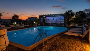 a swimming pool with lounge chairs and a resort at Villa Anemomilos Perissa in Perissa