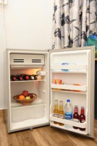a refrigerator with its door open with food and drinks at Bens Inn in Mandrem