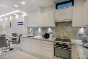 een keuken met witte kasten en een aanrecht bij Luxurious 2 King-size bed flat with Patio in Londen