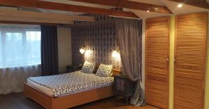 a bedroom with a bed and a large window at Villa del Grossa Будинок з каміном та чаном на дровах in Kuchakiv