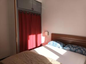 1 dormitorio con 1 cama con cortina roja en Apartamento Roses, 1 dormitorio, 4 personas - ES-258-61, en Roses