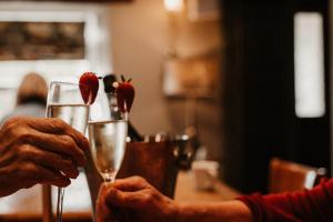 een persoon met een glas champagne met aardbeien erop bij The Wilson Arms in Torver