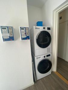 a microwave and a washer and dryer in a room at Hollandse Nieuwe in Katwijk aan Zee