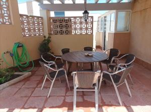 einen Holztisch und Stühle auf einer Terrasse in der Unterkunft Chalet Cabo Palos in Cabo de Palos