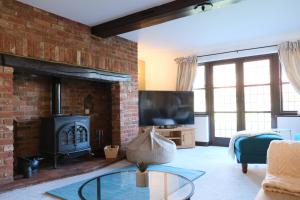 a living room with a fireplace and a tv at Stunning 6 Bedroom House, Free Parking & Garden in Bedford