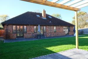 a brick house with a table and a patio at Stunning 6 Bedroom House, Free Parking & Garden in Bedford