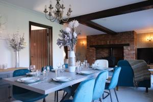 a dining room with a table and blue chairs at Stunning 6 Bedroom House, Free Parking & Garden in Bedford