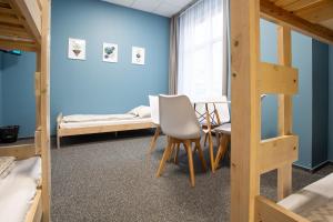 Zimmer mit 2 Etagenbetten, einem Tisch und einem Stuhl in der Unterkunft Moon Hostel Wrocław in Breslau
