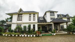 a large white house with black roof at Akim Homestay in Kohīma