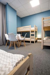 ヴロツワフにあるMoon Hostel Wrocławの二段ベッド2台と椅子2脚が備わる客室です。