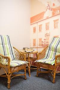 trzy wiklinowe krzesła i stół w pokoju w obiekcie Moon Hostel Wrocław we Wrocławiu