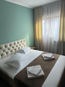 een slaapkamer met een groot bed en 2 handdoeken bij Freedom&Relax in Buzău