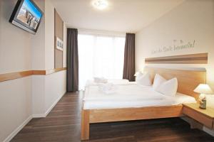 1 dormitorio con 2 camas y TV en la pared en Haus Mecklenburg en Kühlungsborn