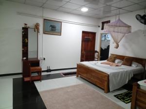 シギリヤにあるsigiriya village hostelの鏡付きの部屋にベッド1台が備わるベッドルーム1室があります。