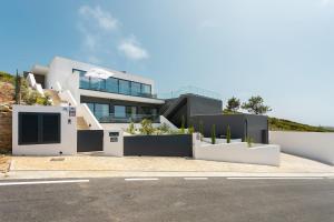 a large white house with plants in front of it at Casa Berlenga - By SCH in Famalicão