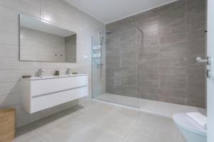 a bathroom with a shower and a sink and a toilet at Casa Berlenga - By SCH in Famalicão +22 photos