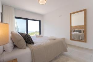 Habitación blanca con cama y espejo en Casa Berlenga - SCH080, en Famalicão
