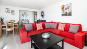 a red couch in a living room with a table at Vilamoura - Spacious with Swimming Pool & View in Vilamoura