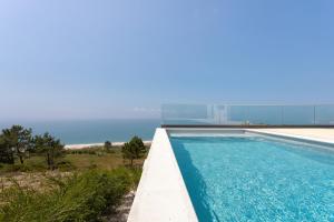 a swimming pool with the ocean in the background at Casa Berlenga - By SCH in Famalicão
