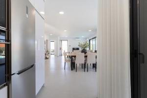 ein Esszimmer mit weißen Wänden und einem Tisch mit Stühlen in der Unterkunft Villa Anita - By SCH in Salir de Porto