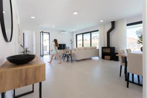 eine Frau, die mit einem Tisch durch ein Wohnzimmer geht in der Unterkunft Villa Anita - By SCH in Salir de Porto