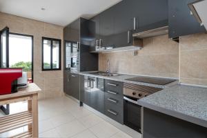 a kitchen with black cabinets and a counter top at Vilamoura - Spacious with Swimming Pool & View in Vilamoura