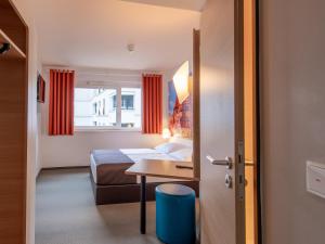 シュヴァインフルトにあるB&B Hotel Schweinfurt-Cityのベッドとテーブルが備わるホテルルームです。