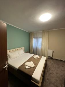 a bedroom with a large bed with two towels on it at Freedom&Relax in Buzău