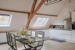 een keuken en eetkamer met een glazen tafel en stoelen bij Amazing 2 ROOMS design apartement Loft in Ieper