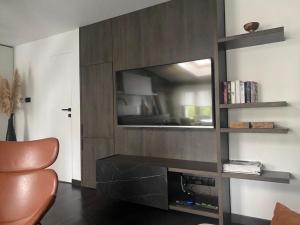 a living room with a television and a chair at Bielawy Suite in Bydgoszcz