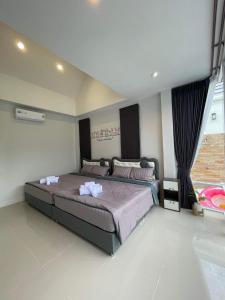 a bedroom with a large bed with towels on it at ATPoolVillaHuaHin เอทีพูลวิลล่าหัวหิน in Ban Wang Bot +32 photos
