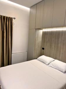 - une chambre avec un lit blanc et un rideau dans l'établissement Sara Apartment, à Strumica