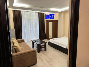 uma sala de estar com uma cama e um sofá em Iko's Family Apartments em Batumi