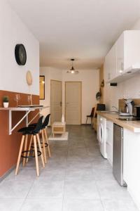 uma cozinha com um balcão e cadeiras num quarto em T2 Idéalement Situé * Hyper Centre/Canal Plus * em Amiens