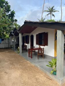 a small house with a table in front of it at Sabine Holiday Resort and Restaurant in Matara