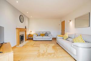 sala de estar con sofá blanco y chimenea en Pentre Nicklaus by MT Property, en Llanelli