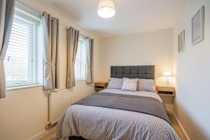 1 dormitorio con 1 cama en una habitación con ventanas en Pentre Nicklaus by MT Property, en Llanelli