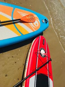 two surfboards sitting on the beach next to the ocean at Villa la Rabolière quartier Lajarrige à La Baule in La Baule