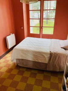 a bedroom with a bed and a window at Villa la Rabolière quartier Lajarrige à La Baule in La Baule