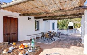 un patio con mesa, sillas y techo de madera. en Cortijo Los Madroños en Frigiliana
