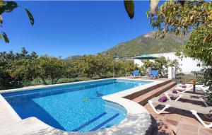 a swimming pool with lounge chairs next to a resort at Cortijo Los Madroños in Frigiliana