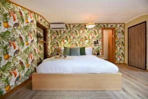 - une chambre avec un grand lit et du papier peint floral dans l'établissement Historic Charm, Modern Comfort - Accommodation in the Heart of The Old Town, à Bucarest