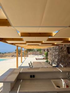 un pabellón con una mesa y sillas bajo un techo en Villa Alisa, en Perdika